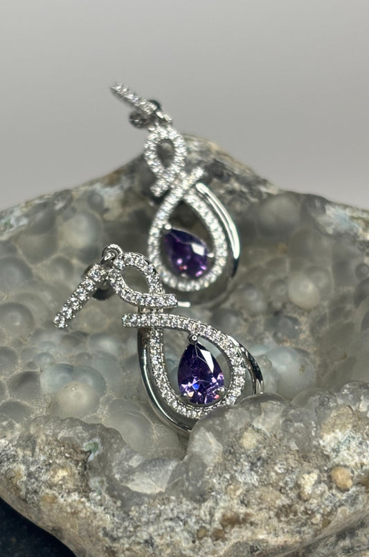 Aretes con zirconitas púrpura corte pera con cerradura de poste en plata 925