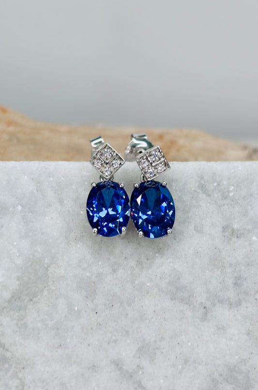 Aretes con zirconitas púrpura corte ovalado con cerradura de poste en plata 925